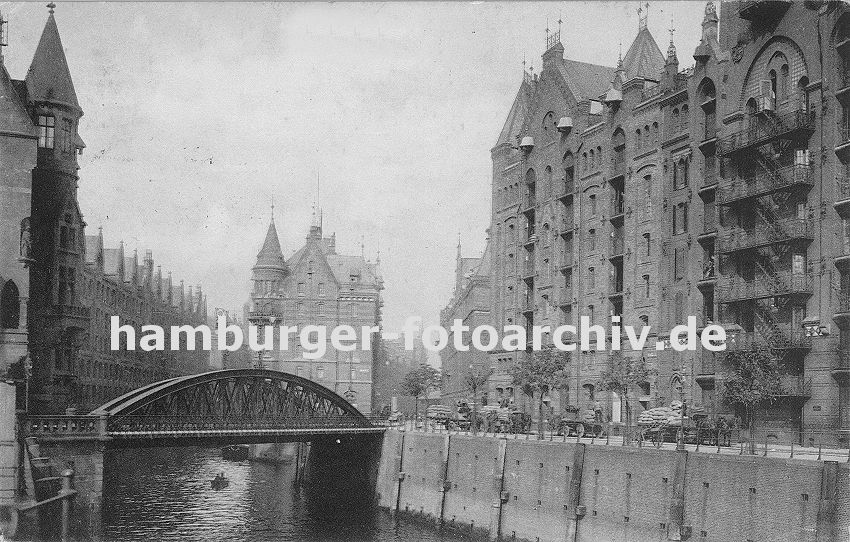 01147729 Bilder aus dem alten Hamburg - Backsteinarchitektur der Hamburger Speicherstadt - mit den unter den Giebeln angebrachten Winden wird die gelagerte Ware von den unterschiedlichen Bden zu den auf der Strasse wartenden Pferdewagen transportiert. Die Wagen sind hoch mit Stapeln von Scken beladen.