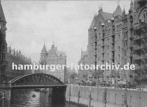 01147729 Backsteinarchitektur der Hamburger Speicherstadt - mit den unter den Giebeln angebrachten Winden wird die gelagerte Ware von den unterschiedlichen Bden zu den auf der Strasse wartenden Pferdewagen transportiert. Die Wagen sind hoch mit Stapeln von Scken beladen.