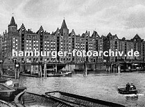 01147734 Blick ber den Brooktorhafen zu den Speicherblcken V + X. Schuten und Khne liegen an der Kaimauer oder den Holz Duckdalben. Eine kleine Barkasse fhrt durch das Hamburger Hafenbecken Richtung Magdeburger Hafen.  