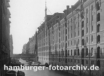 01147737 Blick ber den Brooksfleet Richtung Elbe und dem Hamburger Hafen. Die Schuten liegen auf dem Wasser - das Boot im Vordergrund ist mit Ballen beladen. Die Sonne wirft die Schatten der Giebel an die Speicherwand. 