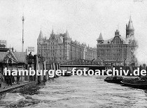 01147742 Anleger am Baumwall; auf dem Ponton stehen Passagieren und warten auf ihr Schiff - ein Schild macht Werbung fr die Hafenrundfahrt. Ein Schlepper zieht eine beladene Schute vom Hamburger Freihafen Richtung Elbe. Im Hintergrund die beiden Speicherblcke A und J, die am Kehrwiederfleet liegen. 