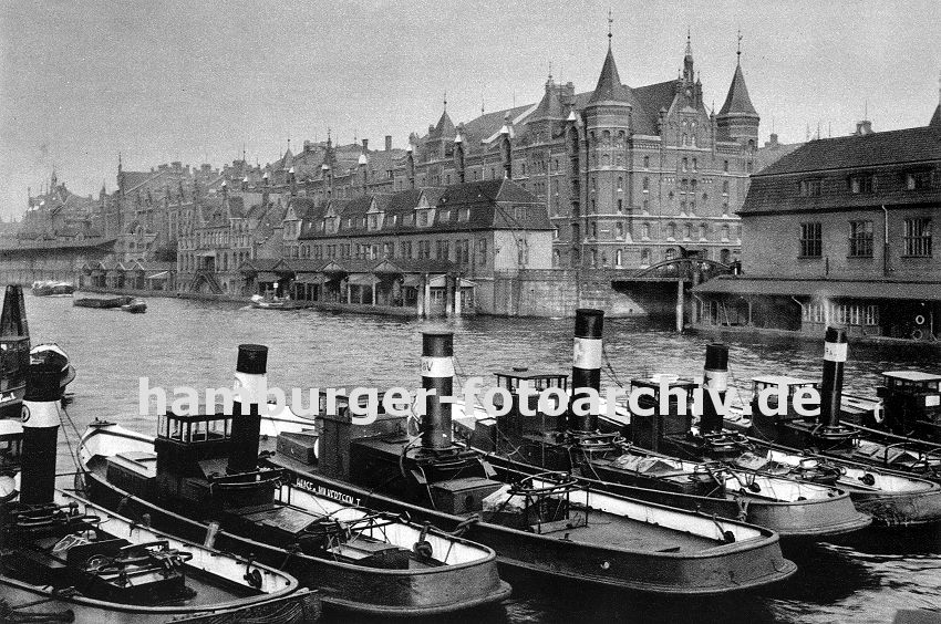 01147744 Fotos von Hamburg / historische Hamburg Bilder -Schlepper liegen unter Dampf im Zollkanal - am Kai der Grenze zum Hamburger Freihafen liegen Zollgebude mit Pontons zum Anlegen der Schiffe, eine Barkasse zieht einen Kahn ber den Kanal.