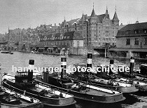 01147744 Schlepper liegen unter Dampf im Zollkanal - am Kai der Grenze zum Hamburger Freihafen liegen Zollgebäude mit Pontons zum Anlegen der Schiffe, eine Barkasse zieht einen Kahn über den Kanal.