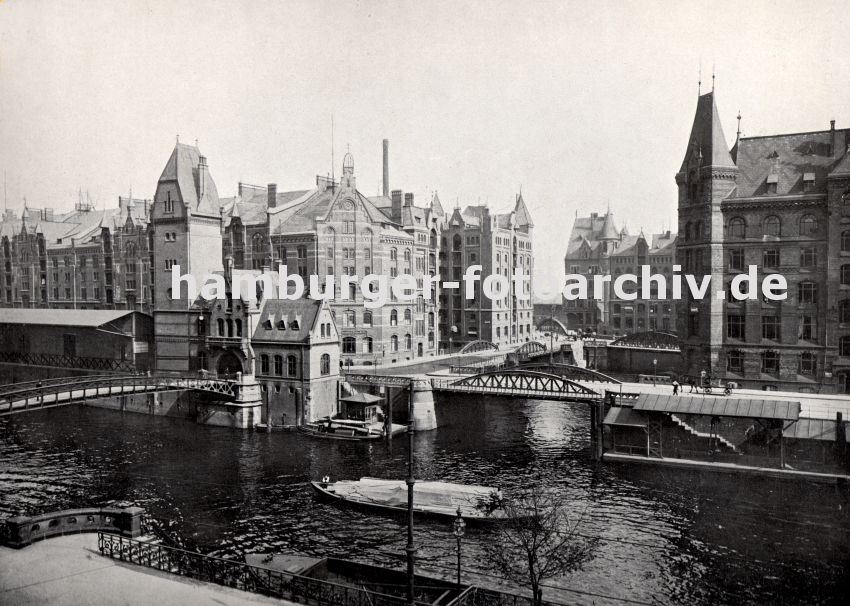 01147745 Blick auf die Speicherstadt - rechts der Block H, dahinter der Kopfbau vom Speicherblock O; links davon der Block Q und hinter der Zollstation der Jungfernbrcke das Speichergebude P. Eine beladene Schute fhrt auf dem Zollkanal, der Schiffer steht im Heck vom Boot - mit einer langen Stange stakt er das Schiff zu seinem Zielort. 