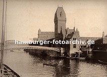 01147746 zwei Mnner staken ihren Kahn mit langen Stangen ber den Zollkanal in Hhe der Fussgngerbrcke Jungfernbrcke - im Hintergrund ist der Bogen der Kornhausbrcke zu erkennen. Auf dem kleinen Schiffsanleger am Kai des Kanals werden in einer hlzernen Zollstation die Ankommenden von einem Zollbeamten kontrolliert.