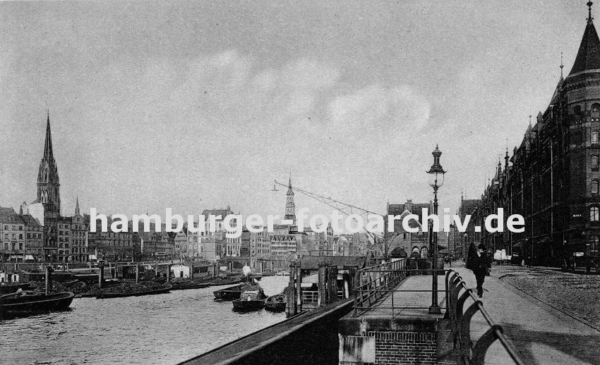 01147747 altes Bild Hamburg // Fassade der Speicherstadt am Kehrwieder - der Zollkanal bildet die Freihafengrenze. Im Binnenhafen liegen Schuten beladen mit Kohle; ein Kahn wird mit einem Schlepper auf dem Kanal gezogen. Die Kirchtrme von der St. Nikolaikirche und der St. Katharinenkirche ragen aus dem Hamburger Husermeer heraus. 