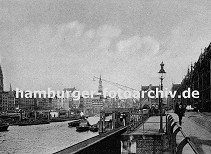 01147747 Fassade der Speicherstadt am Kehrwieder - der Zollkanal bildet die Freihafengrenze. Im Binnenhafen liegen Schuten beladen mit Kohle; ein Kahn wird mit einem Schlepper auf dem Kanal gezogen. Die Kirchtrme von der St. Nikolaikirche und der St. Katharinenkirche ragen aus dem Hamburger Husermeer heraus. 