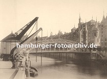 01147748 Blick zur Brooksbrcke, die ber den Zollkanal zum Hamburger Freihafengelnde und der Speicherstadt fhrt. An den Kaimauern des Kanals an der Strasse "Bei dem Neuen Krahn" stehen zwei Krne die die Ladung von den Schiffen an Land hieven. Die Zollstation auf der Brcke ist mit Trmen versehen, die in der Architektur der Neogotik gehalten wurden, wie auch viele architektonische Gestaltungselemente der gesamten Speicherstadt. 