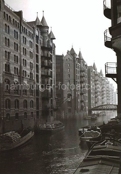 498_3502_108 Schuten haben an den Mauern der Speicherstadt im Wandrahms Fleet fest gemacht. Die Lastkhne sind mit Scken und Kisten beladen. Im Hintergrund die Eisenkonstruktion der Brcke Dienerreihe ber das Fleet.