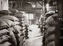 504_271a Ein Quartiersmann steht an der Waage auf dem Speicherboden im Hamburger Freihafen. Der Rohkaffee ist in Jutescken vernht, die auf dem Lagerboden des Speichers gestapelt sind. Schon 1885 wurde mit der Planung zum Bau der Hamburger Speicherstadt begonnen. Es entstand unter der Leitung des zustndigen Oberingenieurs Franz Andreas Meyer in neogotischer Architektur auf einer Gesamtflche von 630 000 der grte zusammenhngende Lagerkomplexes der Welt. Betrieben wurden die Speichergebude von der HFLG, der Hamburger Freihafen-Lagerhaus-Gesellschaft, aus der 1935 nach dem Zusammenschluss mit der Hamburger Kaiverwaltung die Hamburger Hafen- und Lagerhaus Aktiengesellschaft HHLA entstand.