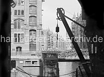 507_10_568 Blick vom Speichergebude H auf die Kannengiesser- ortbrcke und die dahinter liegenden Speicher am Wandrahmsfleet. Mit dem Wandkran konnte die Ware vom Lagerboden auf die Schiffe geladen werden ohne dass die Winden unter dem Dach des Backsteingebudes in Anspruch genommen werden mussten.