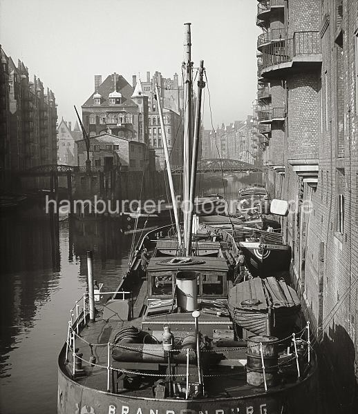 Wandrahmsfleet + Hollndischer Brooks  Fleet, Schiffe; ca. 1948.  507_11_5 Blick von der Poggenmhlenbrcke auf die Fleete der Hamburger Speicherstadt. Links liegt das Hollndische Brooks Fleet mit den Speichern x und V sowie rechts das Wandrahmsfleet mit dem Speichergebude W und hinter der Brcke Dienerreihe die Speicher T und S. Ein Frachter hat am Speicher W fest gemacht, an der Winde wird ein Ballen transportiert. Dahinter eine Schute, an deren Bug die Bezeichnung "Allied Forces" steht.